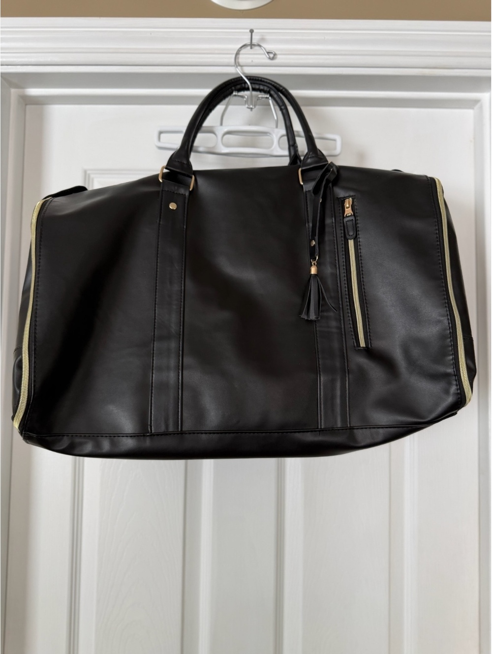 Black duffel bag with gold-tone zippers